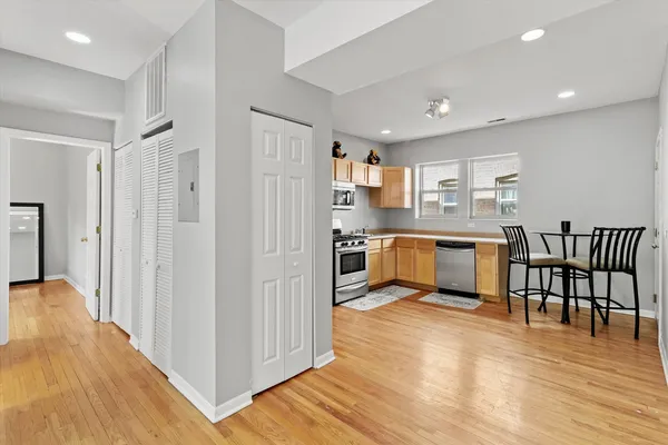a view of kitchen with stainless steel appliances refrigerator oven table and chairs