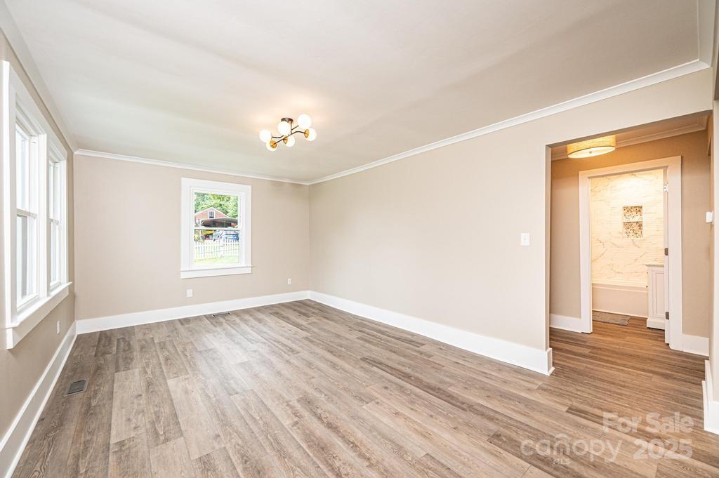 1105 Wildwood Road Lenoir, NC 28645 - Photo 11 of 38 a view of an empty room with wooden floor and a window