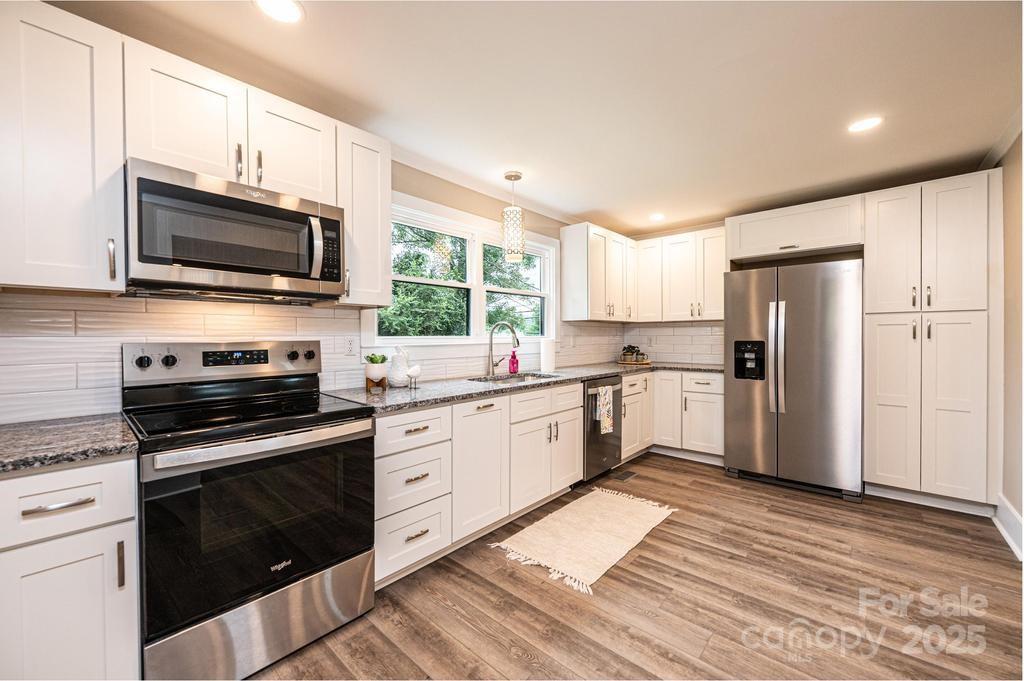 1105 Wildwood Road Lenoir, NC 28645 - Photo 14 of 38 a kitchen with granite countertop a sink cabinets stainless steel appliances and a window
