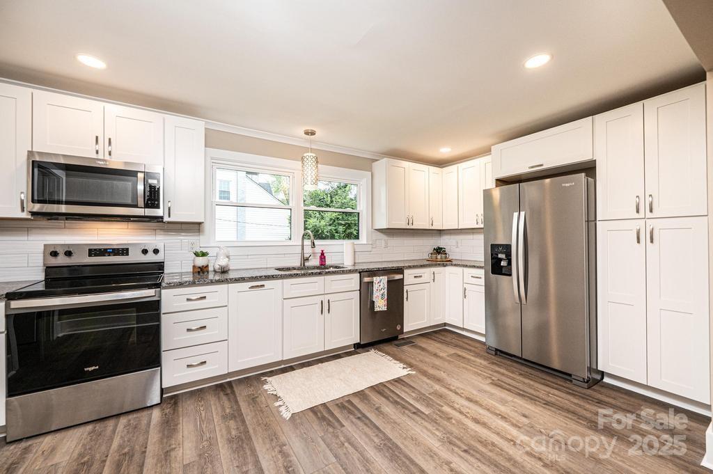 1105 Wildwood Road Lenoir, NC 28645 - Photo 16 of 38 a kitchen with granite countertop a refrigerator stove and microwave
