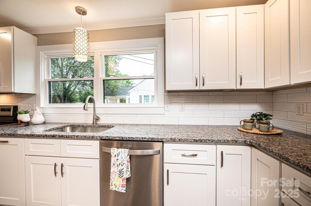 1105 Wildwood Road Lenoir, NC 28645 - Photo 17 of 38 a kitchen with granite countertop white cabinets and a window