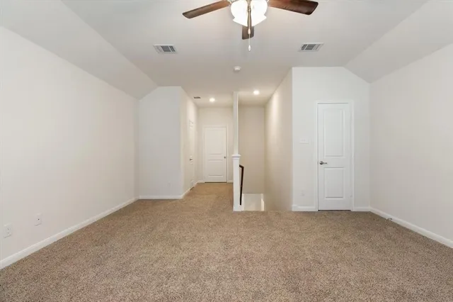 an empty room with a ceiling fan and a window