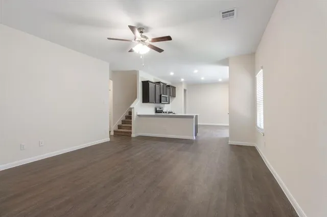 a view of a livingroom with a ceiling fan and wooden floor