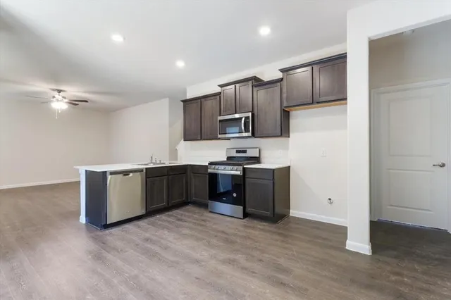 a kitchen with a refrigerator and a stove top oven