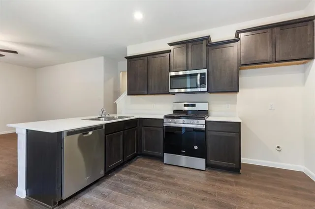 a kitchen with granite countertop wooden cabinets and stainless steel appliances