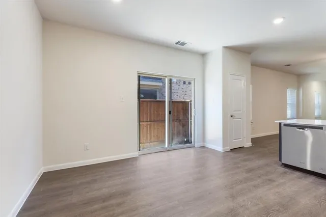an empty room with cabinet and wooden door