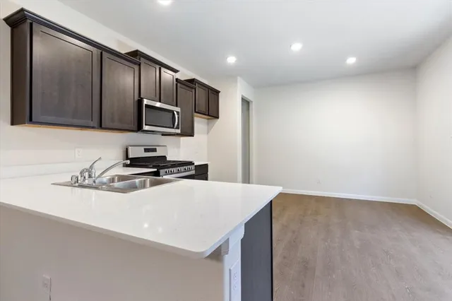 a kitchen with stainless steel appliances a sink stove and refrigerator