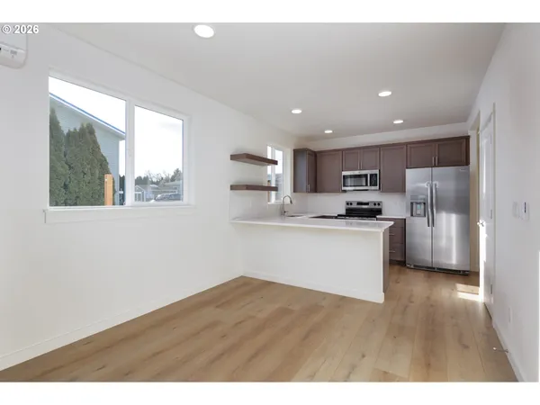 a kitchen with stainless steel appliances granite countertop a refrigerator sink and white cabinets