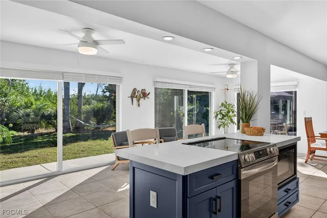 a kitchen with a stove and a view of living room