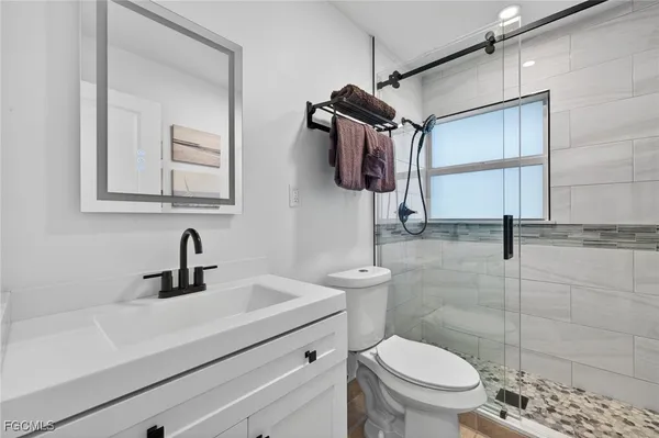 a bathroom with a sink a toilet and shower