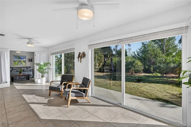 a view of a work space with furniture and floor to ceiling window