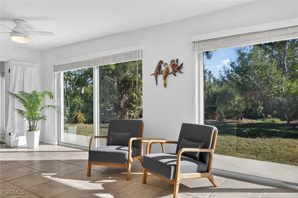 a living room with patio furniture and a garden
