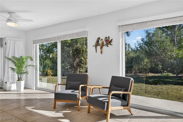 a living room with patio furniture and a garden