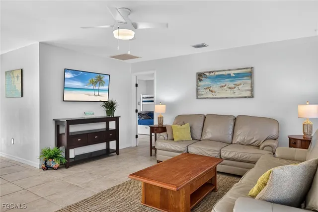 a living room with furniture and a painting on the wall