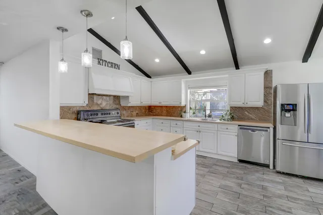 a view of an empty room and wooden floor and a window