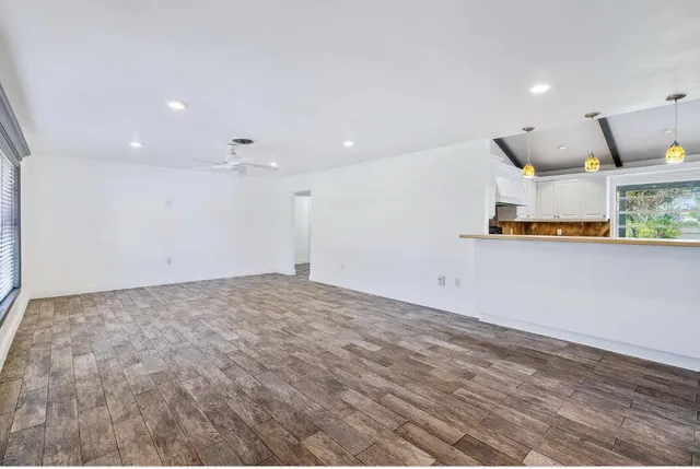 an empty room with kitchen appliances and wooden floor