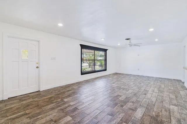 an empty room with kitchen appliances and wooden floor