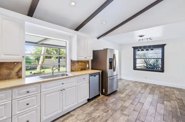 a kitchen with appliances cabinets and a large window