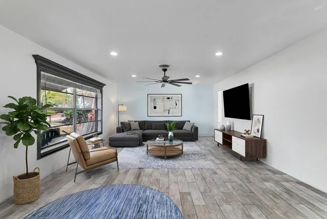 a living room with furniture kitchen and a flat screen tv