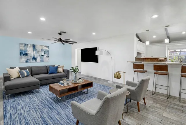 a dining room with furniture potted plants and wooden floor