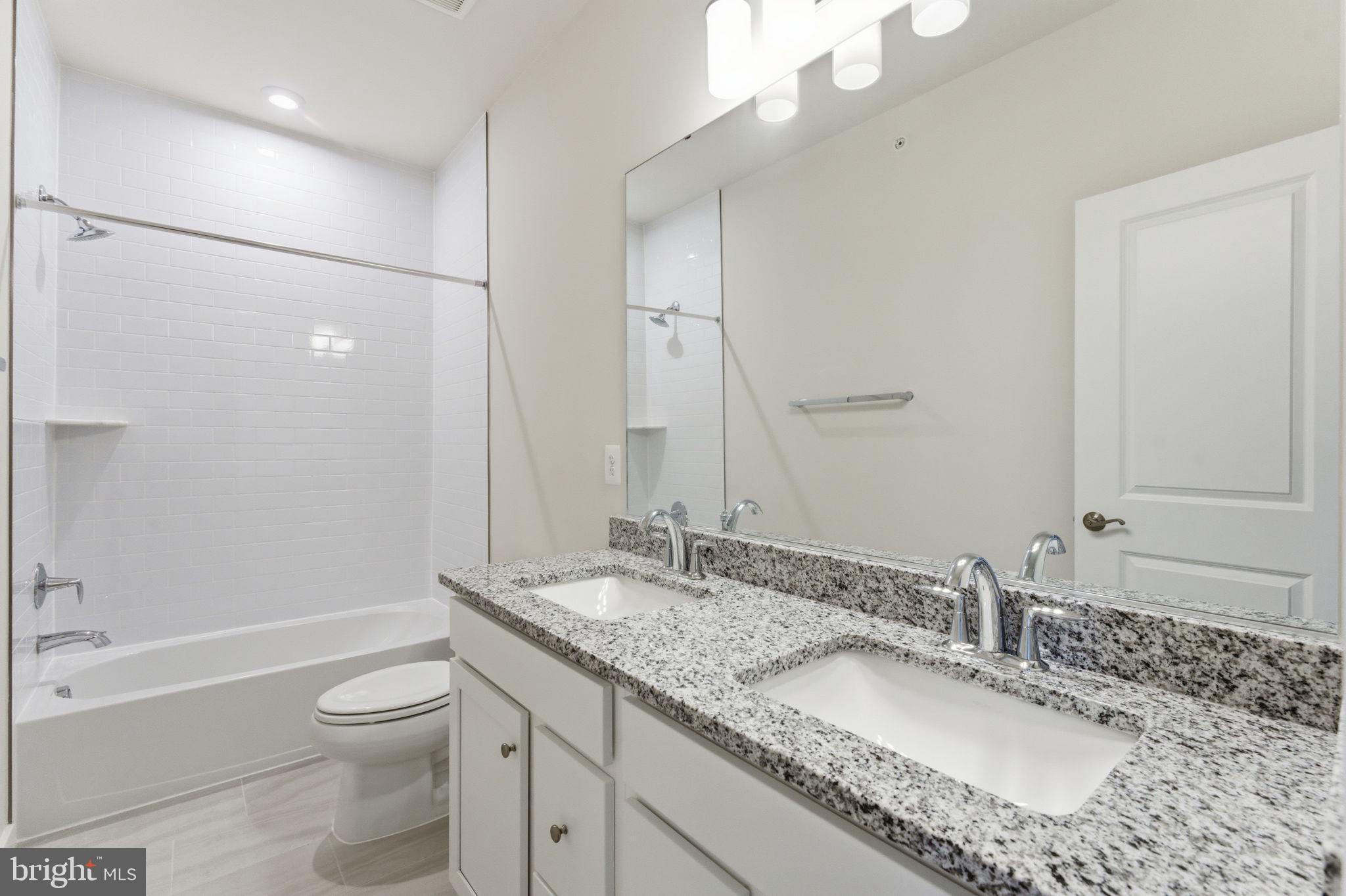 2136 Glacier Road Herndon, VA 20170 - Photo 38 of 79 a bathroom with a granite countertop sink a toilet and shower