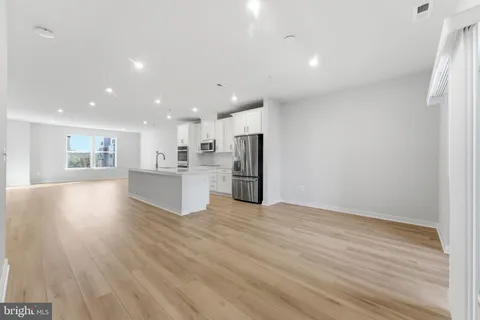 a large kitchen with a large counter top and stainless steel appliances