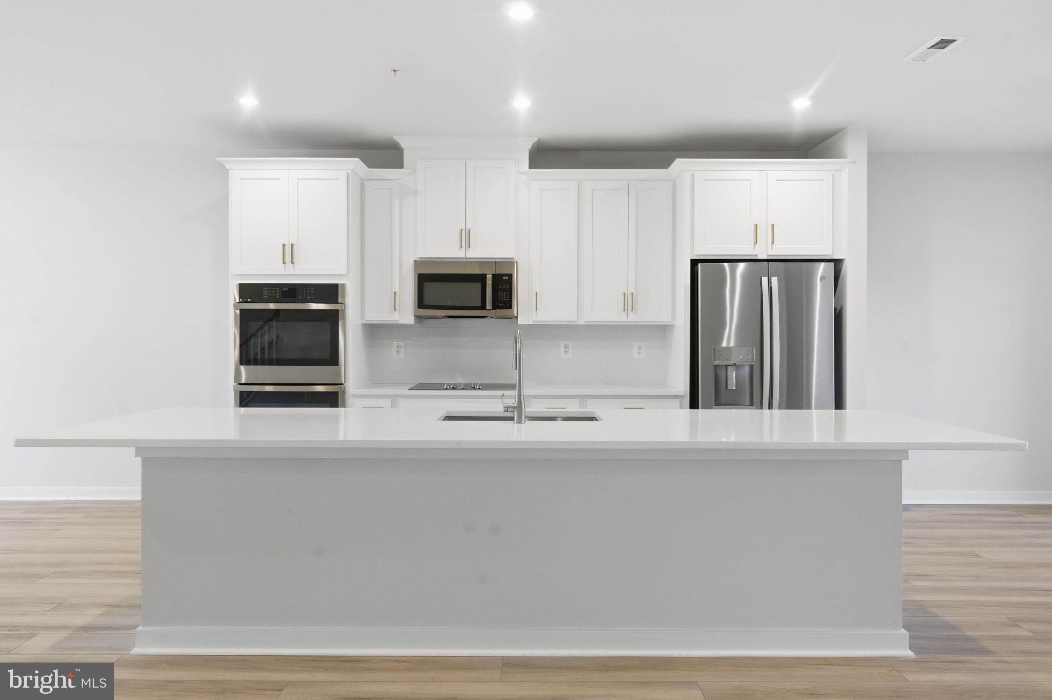 2136 Glacier Road Herndon, VA 20170 - Photo 9 of 79 a kitchen with stainless steel appliances a refrigerator a sink a stove a microwave and wooden cabinets