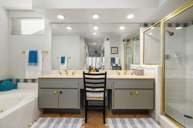 a bathroom with a double vanity sink a mirror and a bathtub