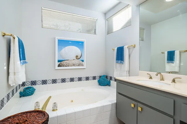 a bathroom with a tub sink and mirror