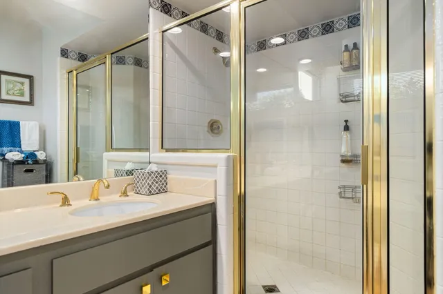 a bathroom with a granite countertop shower sink and mirror