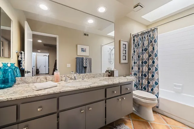 a bathroom with a granite countertop sink toilet and shower