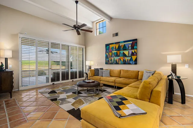 a living room with furniture and a floor to ceiling window