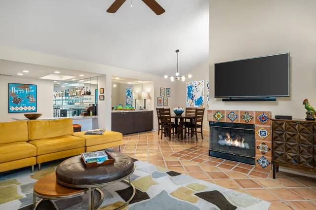 a living room with furniture a dining table and a fireplace