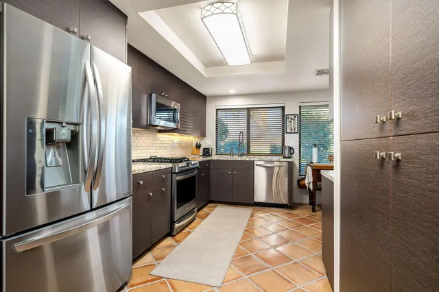 a large kitchen with a stove a refrigerator and a sink