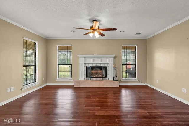 a view of a livingroom with wooden floor fireplace and a window