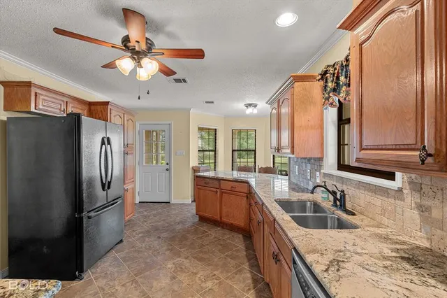 a kitchen with stainless steel appliances granite countertop a sink a stove and a refrigerator
