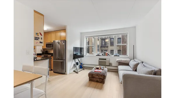 a living room with furniture and a kitchen view