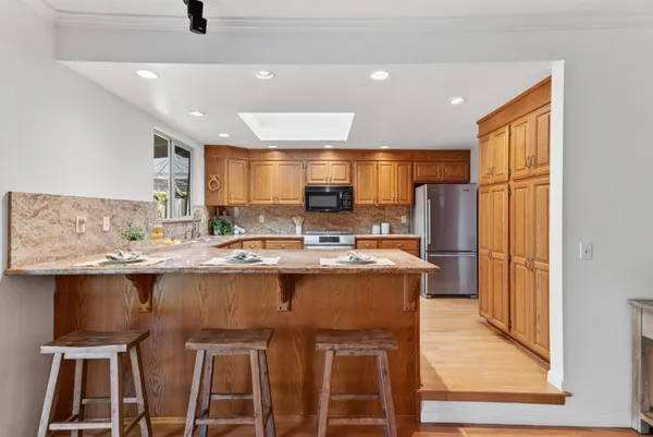a kitchen with stainless steel appliances granite countertop a sink and a refrigerator