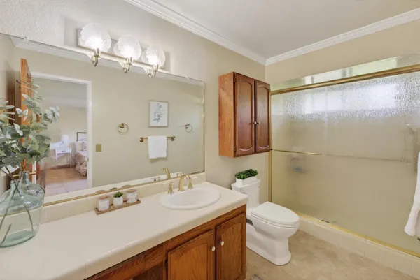 a bathroom with a sink a toilet a mirror and shower
