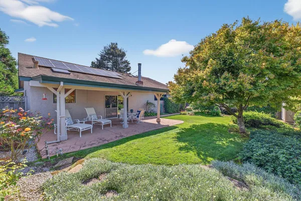 a view of a house with backyard and sitting area
