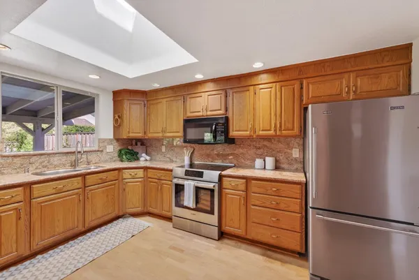 a kitchen with stainless steel appliances granite countertop a refrigerator and a stove top oven
