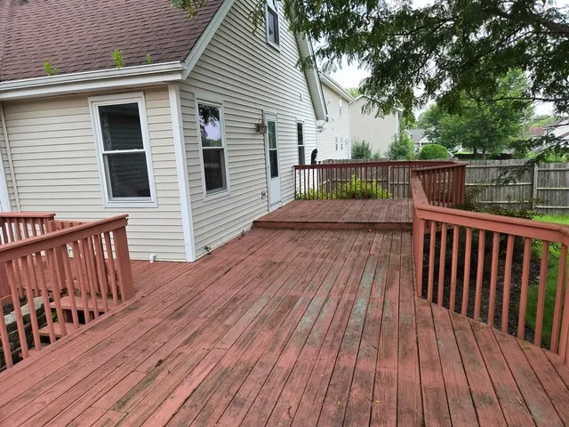 a view of deck with wooden floor and fence with a barbeque grill