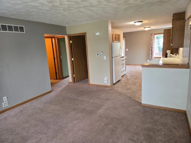 a view of a hallway with furniture and a bathroom
