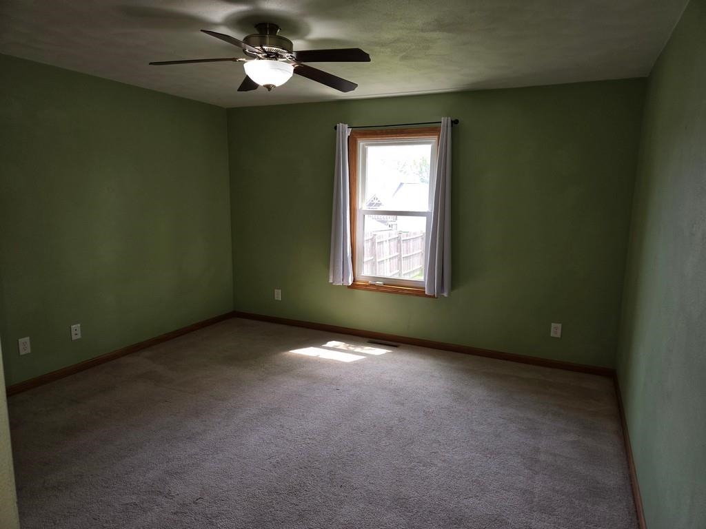 5563 Stockton Drive Rockford, IL 61109 - Photo 9 of 29 an empty room with a window and a fan