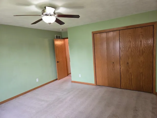 an empty room with a chandelier fan and a chandelier fan