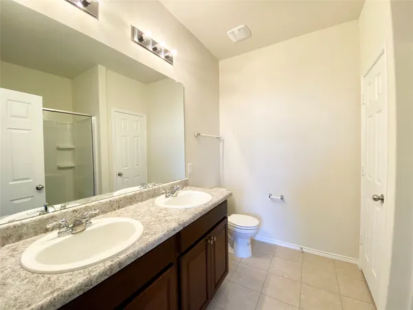 a bathroom with a granite countertop sink a toilet and a mirror