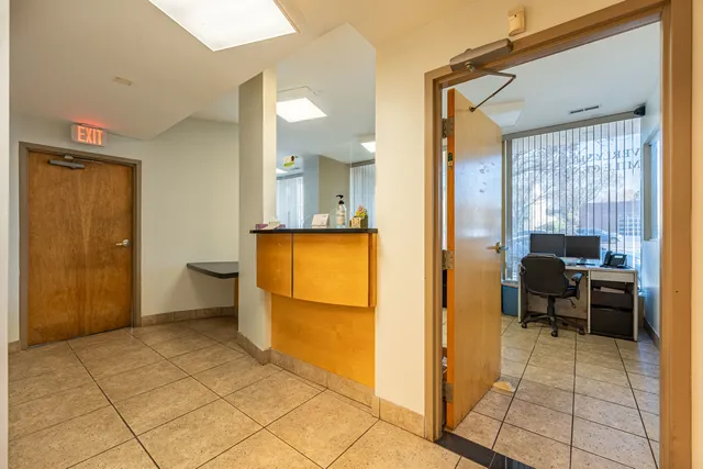a view of a workspace with furniture and a window