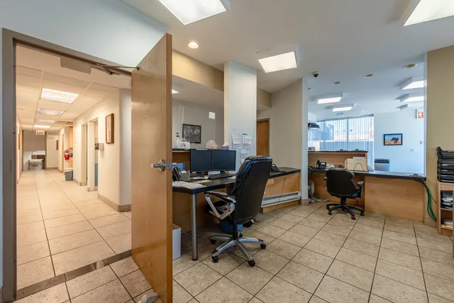 a view of a workspace with furniture and a window