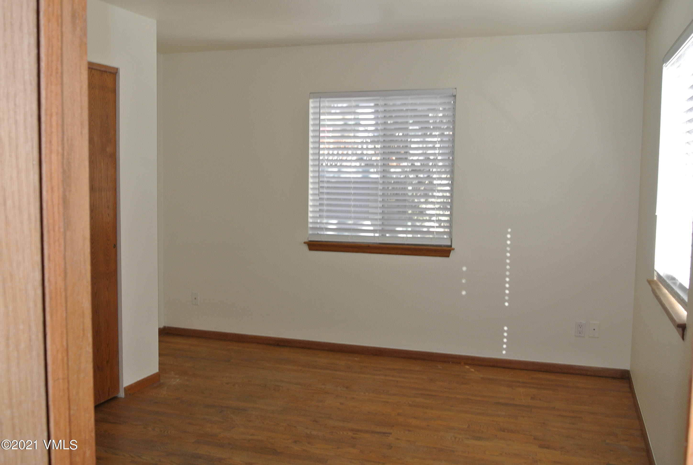 170 Eagle Road, Unit C Avon, CO 81620 - Photo 12 of 16 a view of an empty room with wooden floor and a window