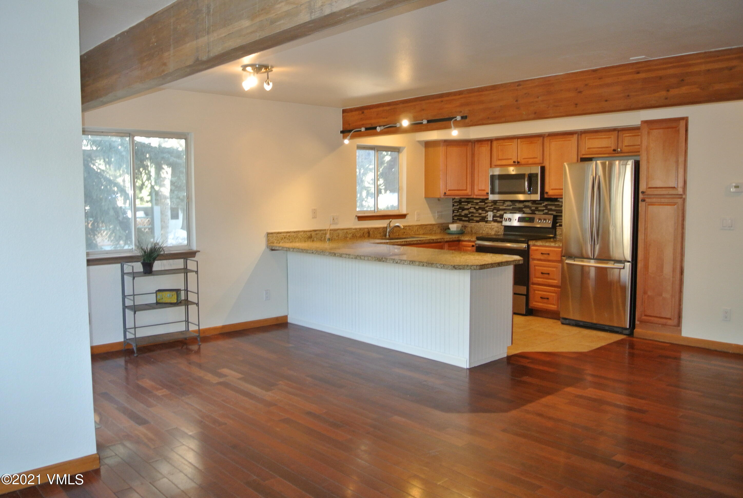 170 Eagle Road, Unit C Avon, CO 81620 - Photo 4 of 16 a kitchen with stainless steel appliances granite countertop a stove a refrigerator and a view of living room